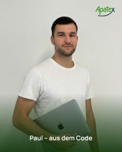 Paul Grund, Mitgründer und Entwickler von Apatex, im weißen T-Shirt mit einem MacBook unter dem Arm.